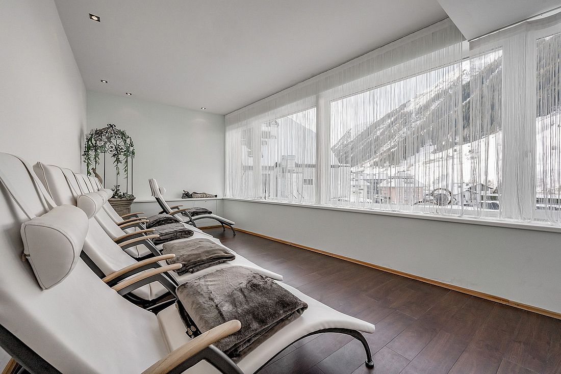 Raum mit Wellnessliegen und Blick auf die verschneiten Berge 