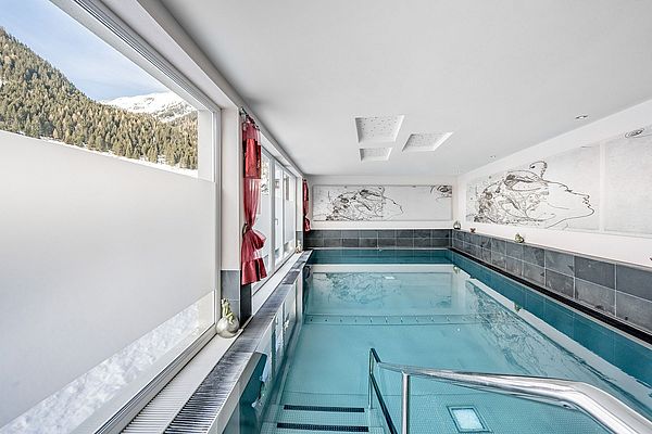 Indoorpool mit Blick auf die verschneite Landschaft