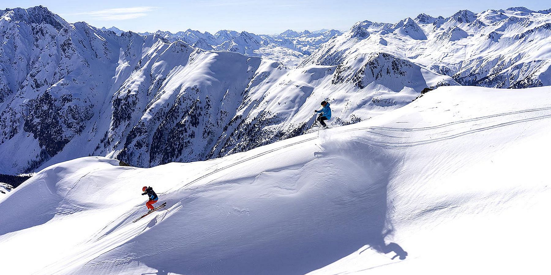 Abseits der Piste springende Skifahrer